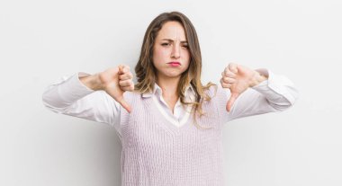 Güzel bir kadın üzgün, hayal kırıklığına uğramış ya da kızgın görünüyor, anlaşmazlık içinde başparmaklarını gösteriyor, hayal kırıklığına uğramış hissediyor.