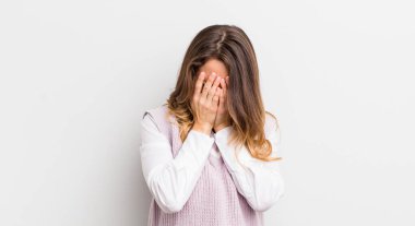 Güzel bir kadın üzgün, hayal kırıklığına uğramış, gergin ve depresif, iki eliyle yüzünü kaplayan, ağlayan