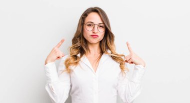 Kötü tavrı olan güzel bir kadın gururlu ve agresif görünüyor, yukarıyı gösteriyor ya da elleriyle alay işareti yapıyor.