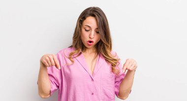 Güzel bir kadın şoke olmuş, ağzı açık ve şaşırmış, inançsızlık ve şaşkınlık içinde bakıyor ve onu işaret ediyor.