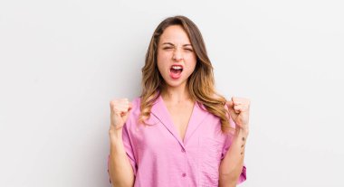 Güzel bir kadın öfkeli bir ifadeyle ya da yumruklarıyla başarıyı kutlarken agresif bir şekilde bağırıyor.