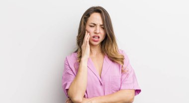 Güzel bir kadın yanağını tutuyor ve ağrılı diş ağrısı çekiyor, hasta, sefil ve mutsuz hissediyor, dişçi arıyor.