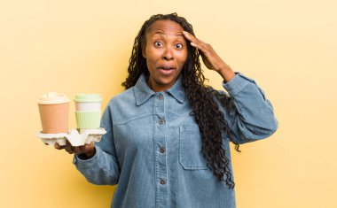 siyah güzel kadın mutlu, şaşkın ve şaşkın görünüyor.