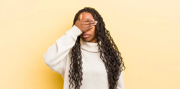 stock image black pretty woman covering eyes with one hand feeling scared or anxious, wondering or blindly waiting for a surprise