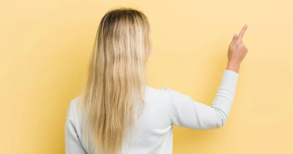 Blonde Caucasian Woman Standing Pointing Object Copy Space Rear View — Stockfoto