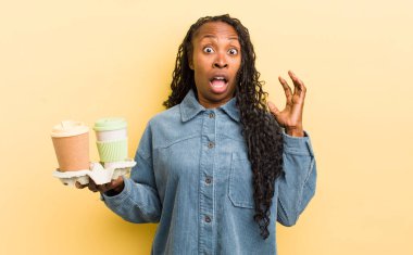 Siyah güzel bir kadın ellerini havaya kaldırarak çığlık atıyor.