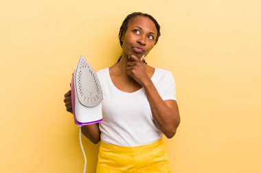 Siyah güzel kadın düşünüyor, kuşkulu ve şaşkın hissediyor.