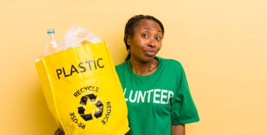 Siyah güzel bir kadın omuz silkiyor, kafası karışık ve kararsız.