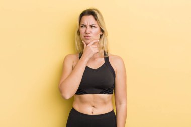 Sarışın, güzel, düşünceli, kuşkulu ve kafası karışık bir kadın.