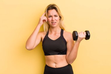 Sarışın, güzel bir kadın. Kafası karışık ve şaşkın. Deli olduğunu gösteriyor.