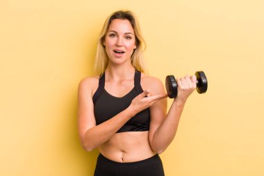 Sarışın, güzel bir kadın neşeyle gülümsüyor, mutlu hissediyor ve bir konsept gösteriyor.