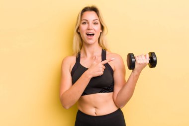 Sarışın, güzel bir kadın heyecanlı ve şaşırmış görünüyor.