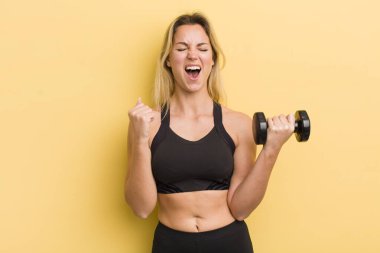 Sarışın, güzel bir kadın sinirli bir ifadeyle saldırganca bağırıyor.