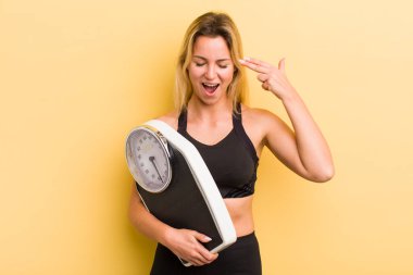 Sarışın, güzel bir kadın mutsuz ve stresli görünüyor. İntihar işareti yapıyor.