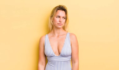 Sarışın, güzel bir kadın üzgün, üzgün ya da kızgın ve yan tarafa bakıyor.