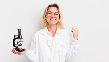 Sarışın, güzel bir kadın şokta, gülüyor ve başarıyı kutluyor.