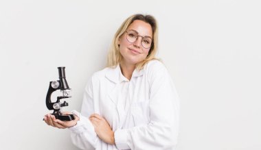 Sarışın, güzel bir kadın omuz silkiyor, kafası karışık ve kararsız.