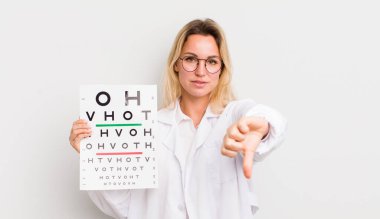 Sarışın, güzel bir kadın kendini kötü hissediyor, baş parmağını kaldırıyor.