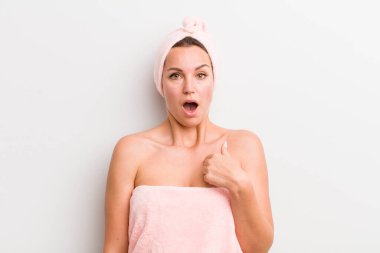 Şok olmuş ve ağzı açık, kendini işaret eden sarışın güzel bir kadın.