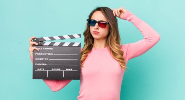 Güzel kadın şaşkın ve kafası karışmış hissediyor, başını kaşıyor.