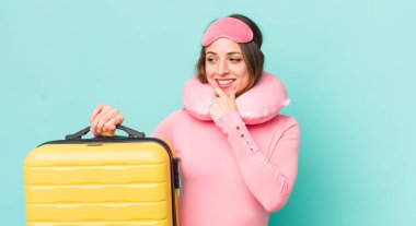 Güzel bir kadın mutlu, kendinden emin bir ifadeyle gülümsüyor, elleri çenesinde.