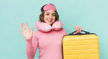 Güzel bir kadın mutlu bir şekilde gülümser, el sallar, hoş karşılar ve seni selamlar.