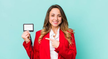 Güzel bir kadın neşeyle gülümsüyor, mutlu hissediyor ve bir tarafı işaret ediyor.