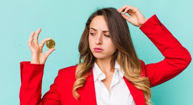 Güzel kadın şaşkın ve kafası karışmış hissediyor, başını kaşıyor.