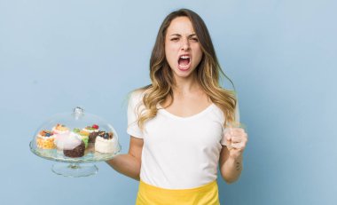 Güzel bir kadın sinirli bir ifadeyle agresif bir şekilde bağırıyor.