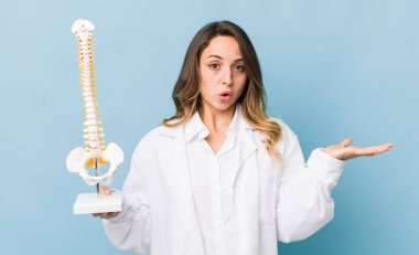 Güzel bir kadın şaşırmış ve şok olmuş görünüyor, çenesi düşmüş bir nesne tutuyor.