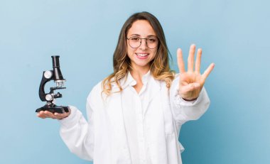 Güzel bayan gülümsüyor ve arkadaş canlısı görünüyor, dört numarayı gösteriyor.