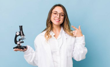 Kendine güvenen güzel bir kadın kendi gülüşünü işaret ediyor.