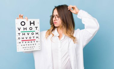 Güzel kadın şaşkın ve kafası karışmış hissediyor, başını kaşıyor.