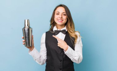 Güzel bir kadın neşeyle gülümsüyor, mutlu hissediyor ve bir tarafı işaret ediyor.