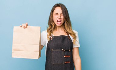 Güzel kadın agresif bir şekilde bağırıyor, çok kızgın görünüyor.