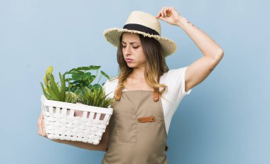 Güzel kadın şaşkın ve kafası karışmış hissediyor, başını kaşıyor.