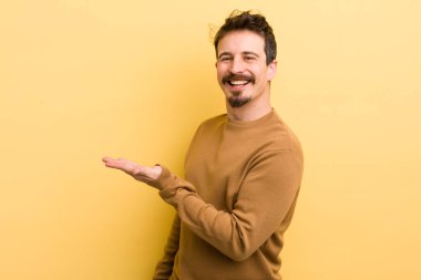 Genç mutlu adam bir şeyler gösteriyor.