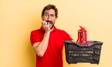 Elinde boş bir alışveriş sepeti olan genç çılgın adam.