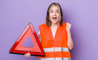 Kafkasyalı bir kadın şoke olmuş, gülüyor ve başarıyı kutluyor. araba üçgeni kavramı