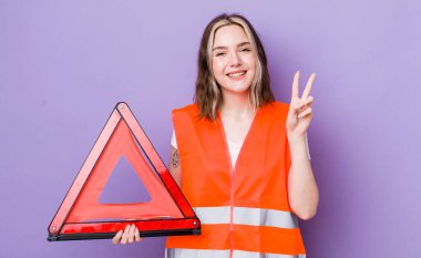 Güzel beyaz kadın gülümseyen ve mutlu görünen, zafer ya da barış işareti yapan. araba üçgeni kavramı