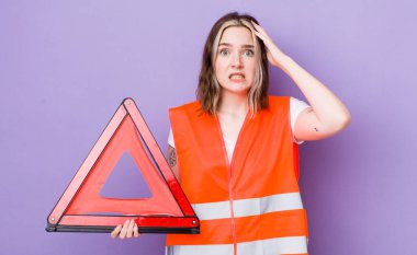 Kafkasyalı bir kadın stresli, endişeli ya da korkmuş, elleri başının üstünde. araba üçgeni kavramı