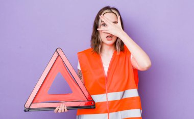 Güzel, beyaz bir kadın şok olmuş, korkmuş ya da korkmuş görünüyor. Yüzü elle kapatılmış. araba üçgeni kavramı