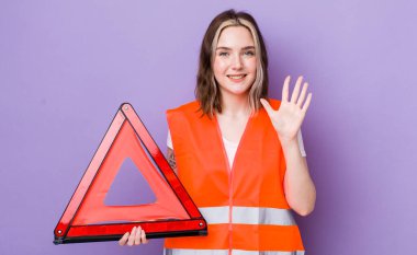 Güzel beyaz kadın gülümsüyor ve arkadaş canlısı görünüyor, beş numarayı gösteriyor. araba üçgeni kavramı