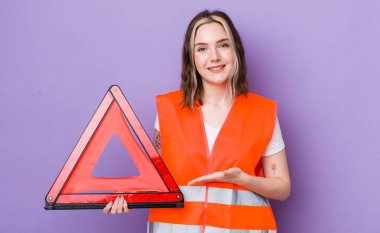 Güzel, beyaz bir kadın neşeyle gülümsüyor, mutlu hissediyor ve bir konsept gösteriyor. araba üçgeni kavramı