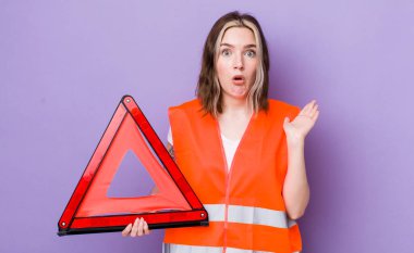 Kafkasyalı bir kadın şaşırmış ve şok olmuş görünüyor. Çenesi düşmüş ve elinde bir nesne var. araba üçgeni kavramı