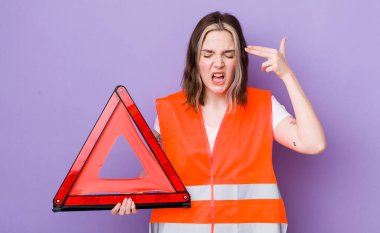 Oldukça beyaz bir kadın mutsuz ve stresli görünüyor, intihar jesti silah işareti yapıyor. araba üçgeni kavramı