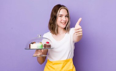 Güzel, beyaz bir kadın gururlu, olumlu gülümsüyor. Ev yapımı kek konsepti