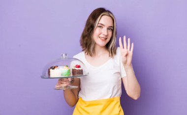 Güzel beyaz kadın gülümsüyor ve arkadaş canlısı görünüyor, dört numarayı gösteriyor. Ev yapımı kek konsepti