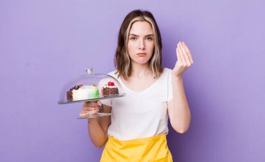 Kafkasyalı güzel bir kadın kapiş ya da para hareketi yapıyor, sana ödemeni söylüyor. Ev yapımı kek konsepti