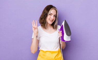 Güzel beyaz kadın gülümsüyor ve arkadaş canlısı görünüyor, üç numarayı gösteriyor. el demiri konsepti